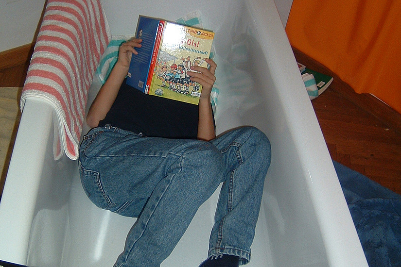 Junge liest in der bookolino-Badewanne