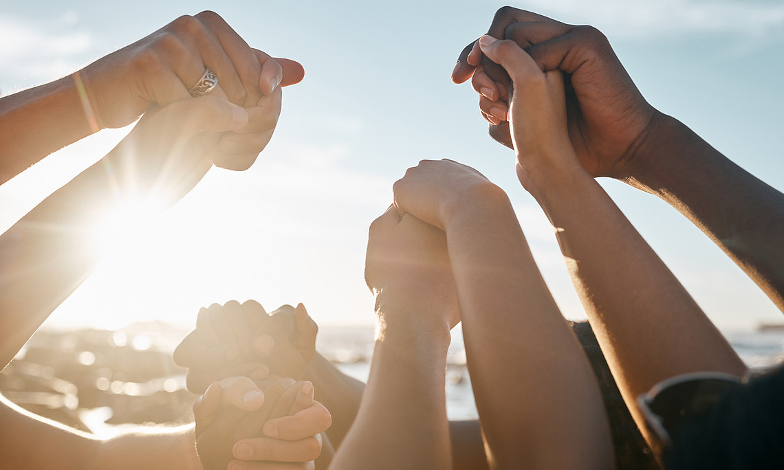 Friends, bonding and holding hands on beach social gathering, community trust support or summer holiday success. Men, women and diversity people in solidarity