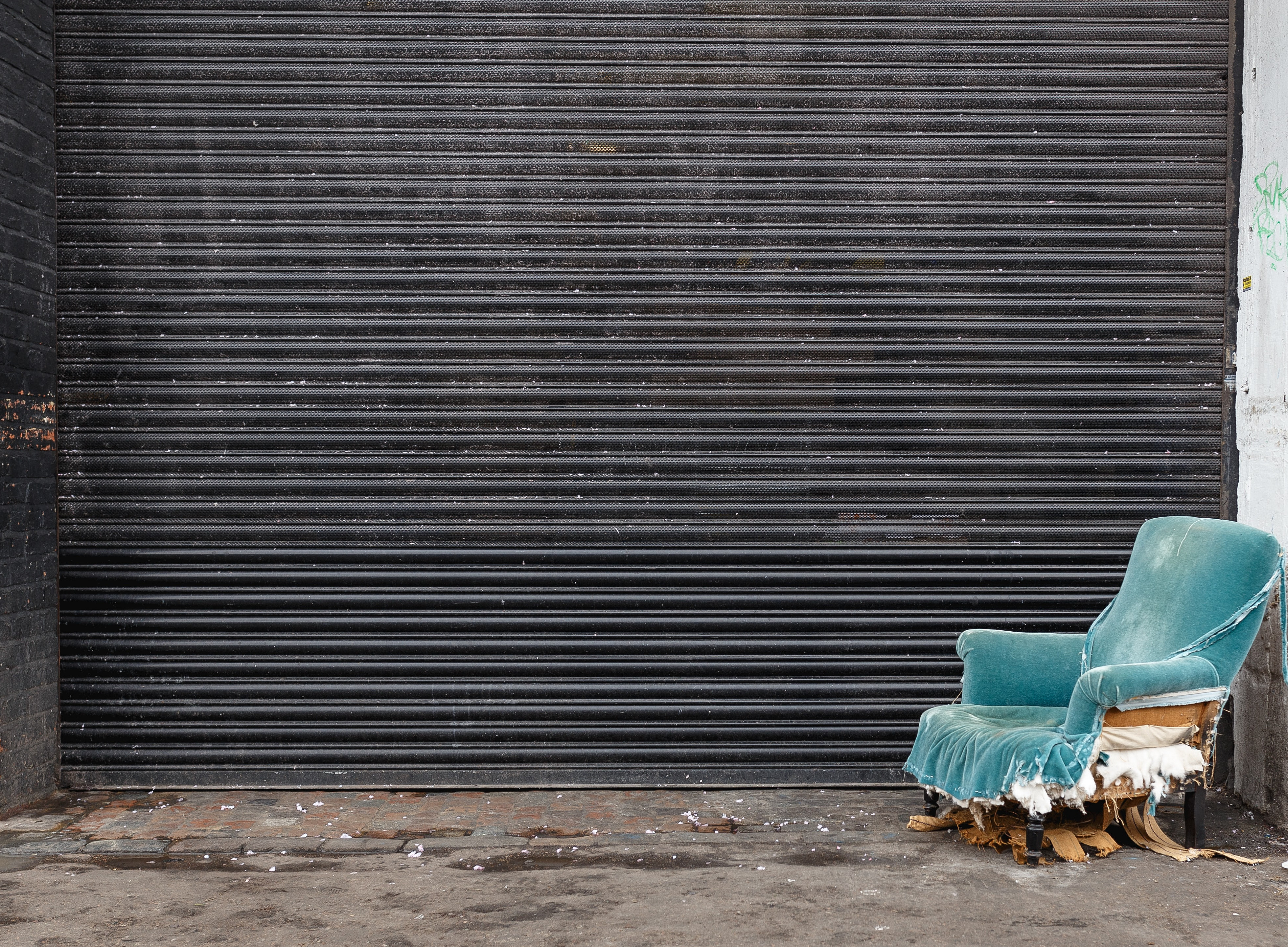 Sanierung von Unternehmen: kaputter Sessel vor geschlossenem Garagentor 