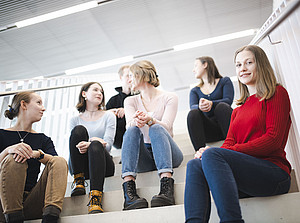 Eine Gruppe junger Benutzer:innen sitzt auf der Treppe und unterhält sich. ©Uni Graz/Tzivanopoulos