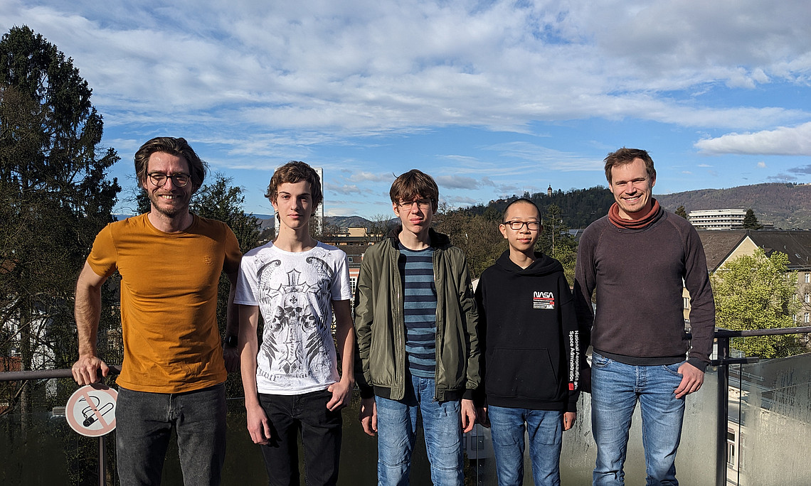 Auf dem Bild sind die 3 teilnehmenden Schüler und die zwei Betreuer der Universität Graz zu sehen