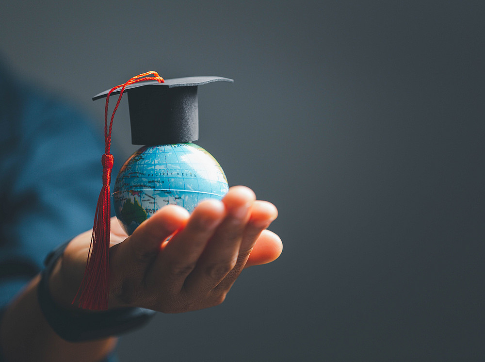 A graduate:inside hat on a globe ©stock.adobe.com/JD8