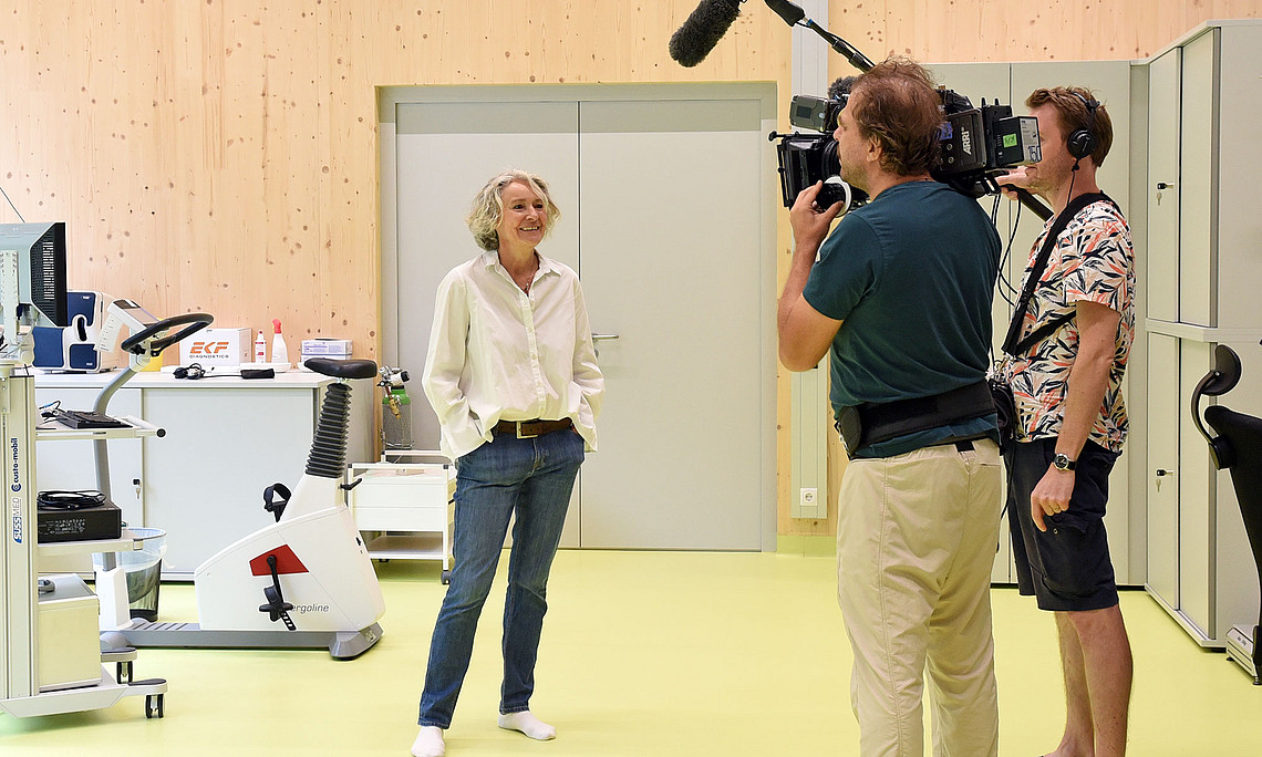 Claudia Traunmüller vor einer Teststraße im Trainings- und Diagnostikzentrum der Uni Graz am Rosenhain mit einem Kamerateam 