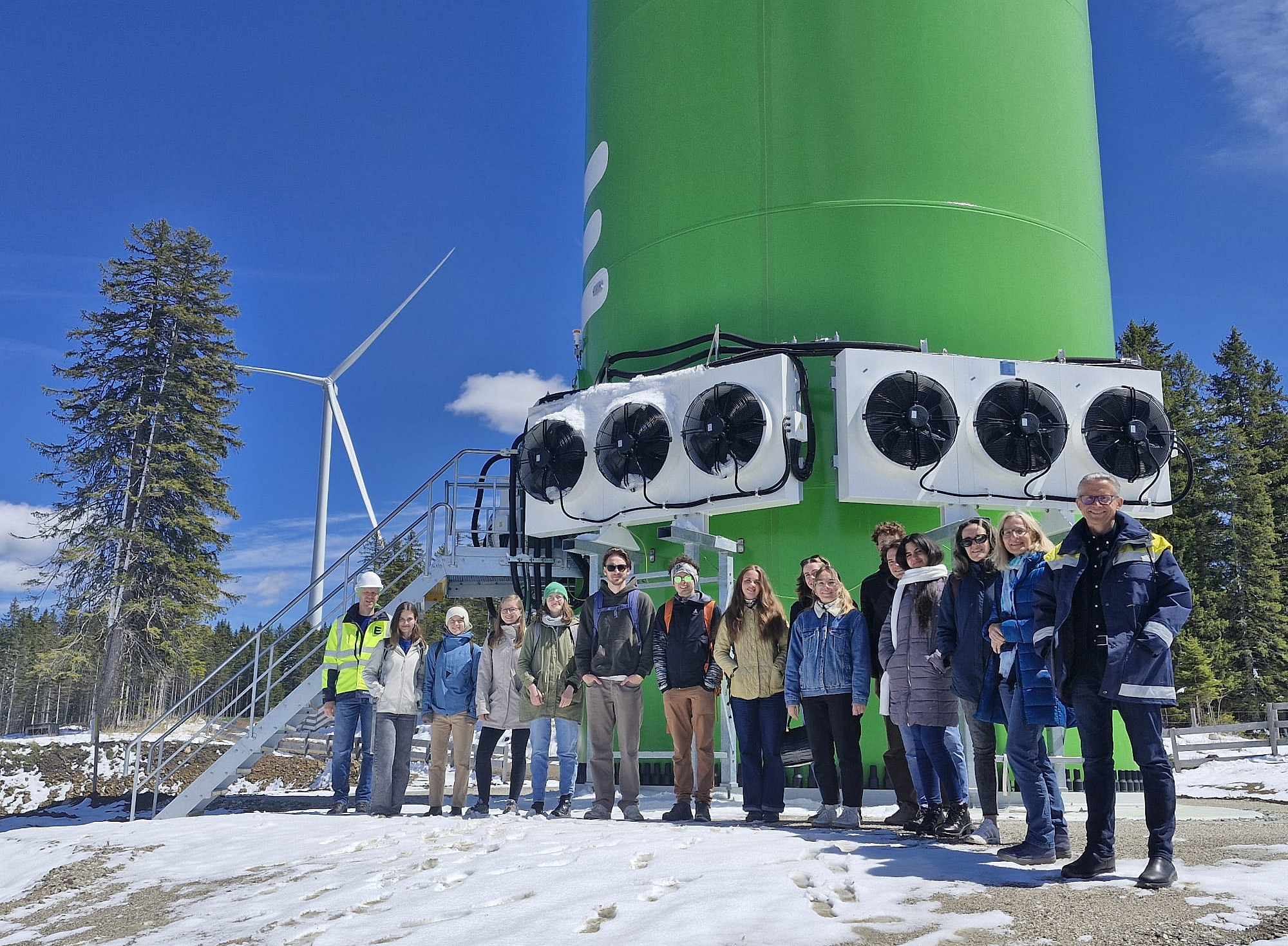 Exkursionsteilnehmer:innen vor dem Fuß der Windkraftanlage ©Pirstner-Ebner