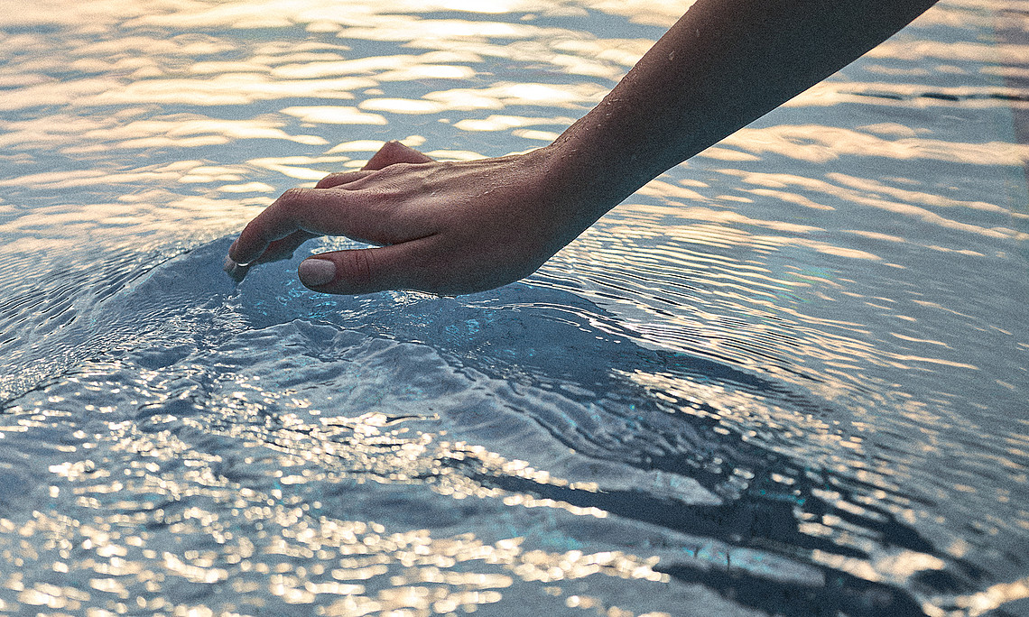Hand greift ins Wasser