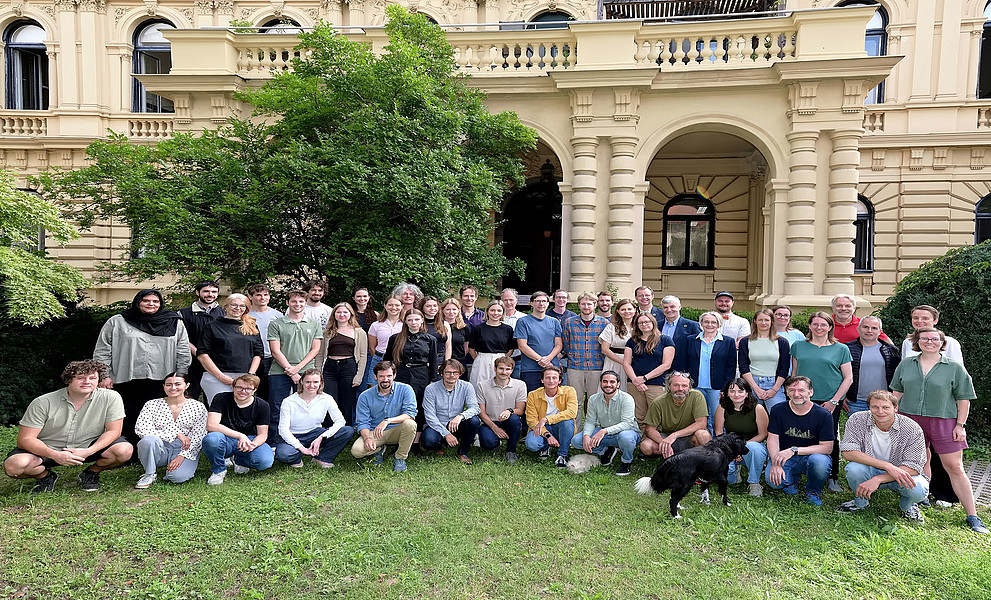 Gruppenfoto vom Team des Wegener Centers im Grünen vor der Villa in der Brandhofgasse, in dem die Einrichtung beheimatet ist.