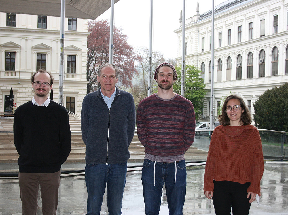 Vier Personen im Gruppenfoto, dahinter die Universitätsbibliothek der Uni Graz, Projekttam Agent-based Economic Epidemiology ©Graz Schumpeter Centre