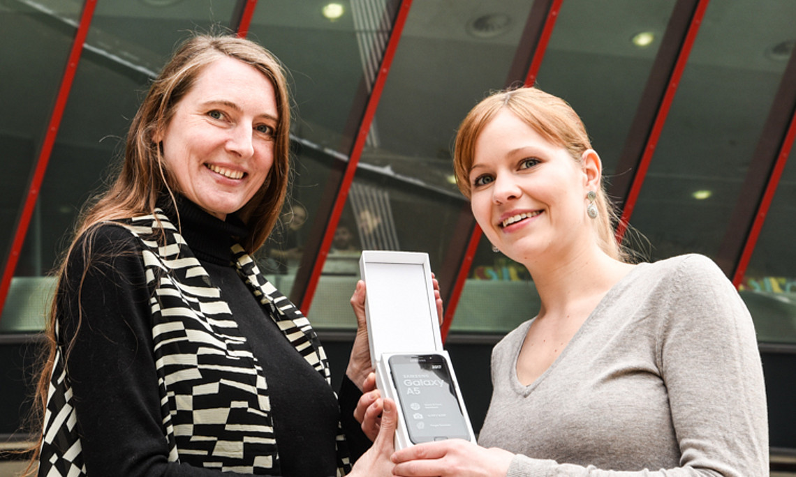 Silvia Rainer (links) überreichte im Namen der Uni Graz das brandneue Smartphone an die Gewinnerin Yvonne Hörzer. Foto: Uni Graz/Tzivanopoulos