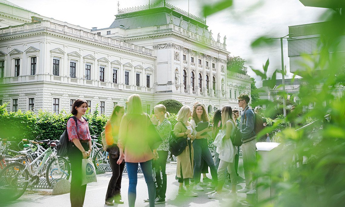 Studierende im Frühling vor dem Hautgebäude der Universität Graz