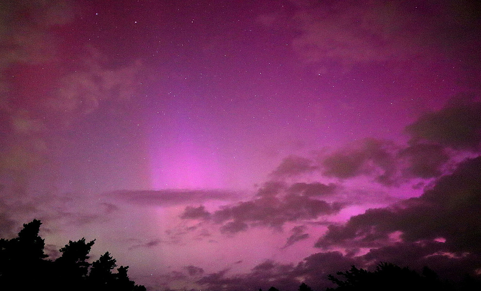 Nachthimmel, leuchtend in bunten Farben mit den Sternen im Hintergrund.