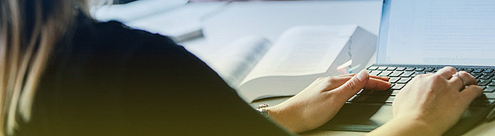 Symbolic image. A woman sits in the listening room with a notebook and writes down what she has heard ©Uni Graz/Kanizaj