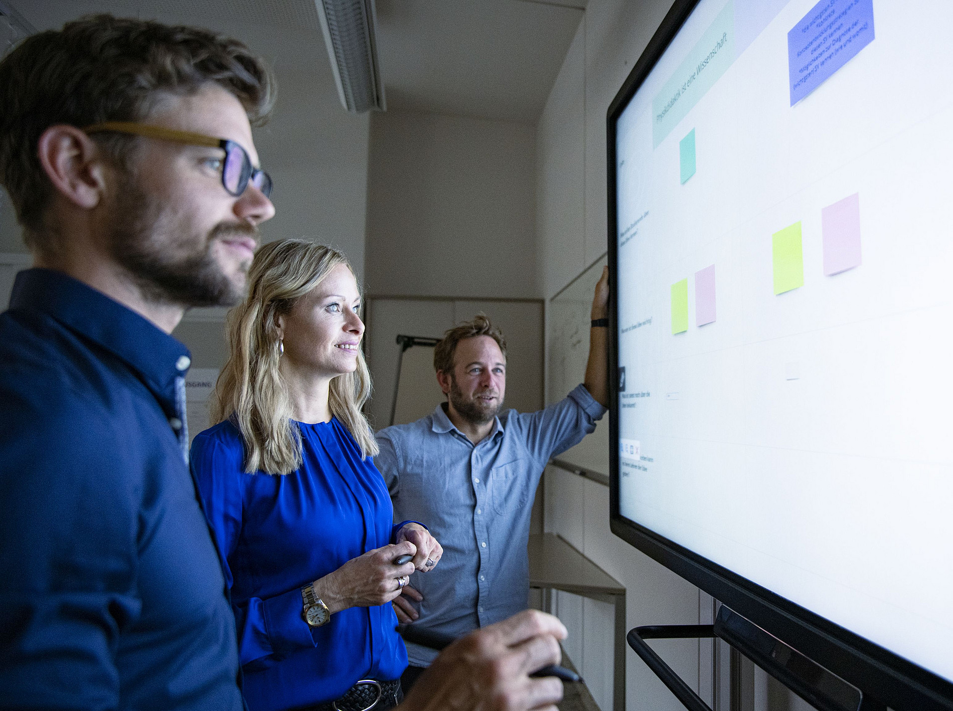 Das Bild zeigt drei Personen die vor einem Smartboard stehen und sich Daten ansehen. ©Uni Graz/Tzivanopoulos