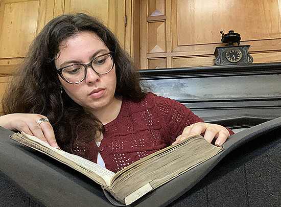Frau mit Locken schaut in ein Buch ©Universitat de Barcelona