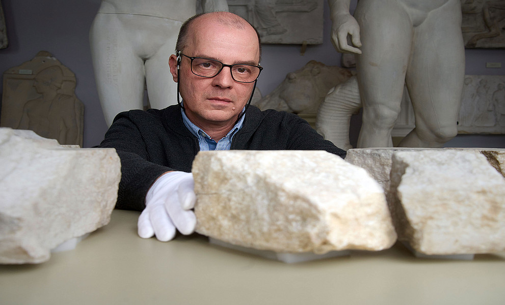 Archäologe Stephan Karl fügt zwei Bruchstücke einer Mensaplatte zusammen