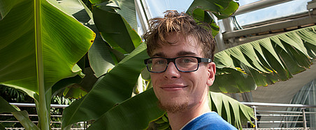 Porträt eines jungen Mannes vor einer Palme 