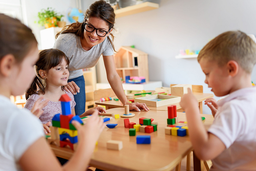 Kinder mit bunten Holzwürfeln am Tisch symbolisieren das Forschungsprojekt Plan ICF ©Nemanja Mandic - stock.adobe.com