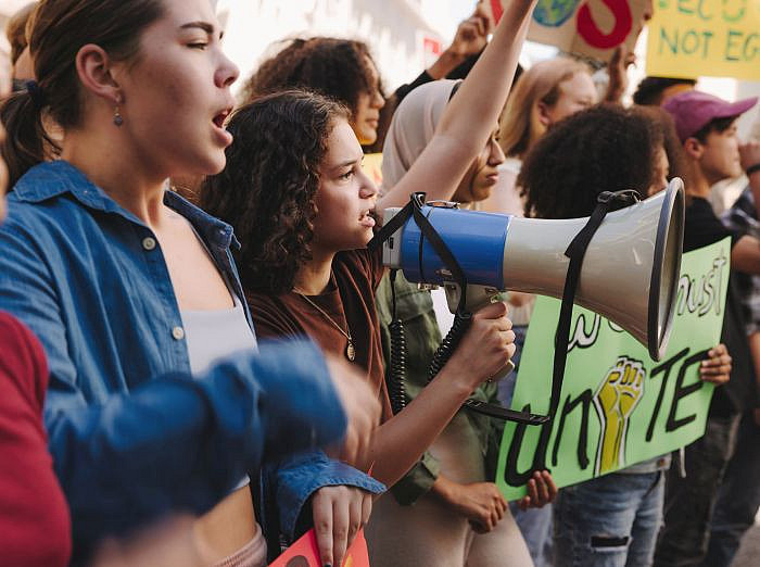 Demonstrierende junge Menschen mit Plakaten und einem Megaphon ©Jacob Lund Photography - stock.adobe.com