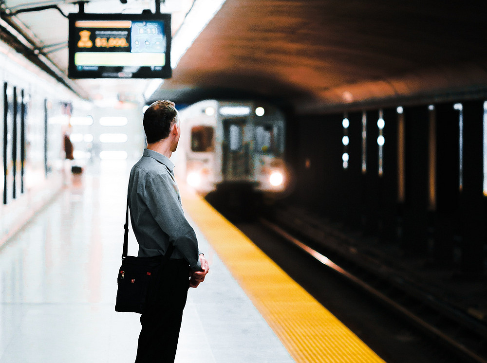 A platform; a train/subway is just arriving. A person with a shoulder bag stands on the track and faces the wagon. ©Marcelo Cidrack - unsplash.com