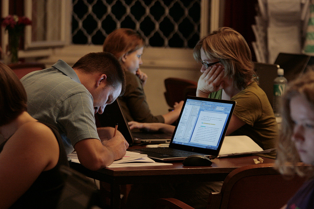 Students sit at a table and work on their laptops. ©Franz-Josef Schimpl