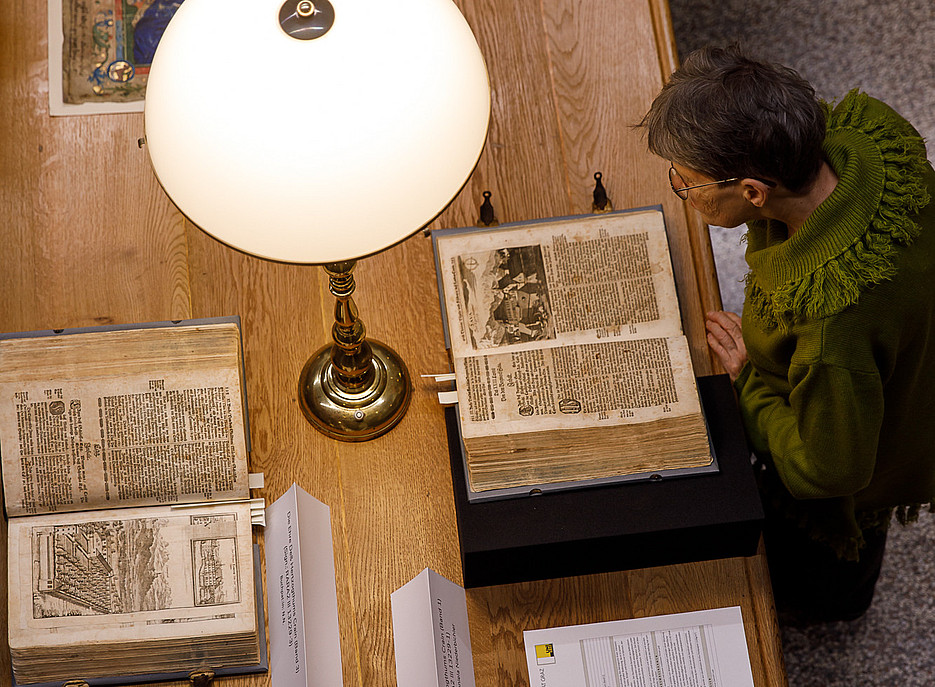 Eine Frau schaut sich eine Handschrift an ©Uni Graz/Luef