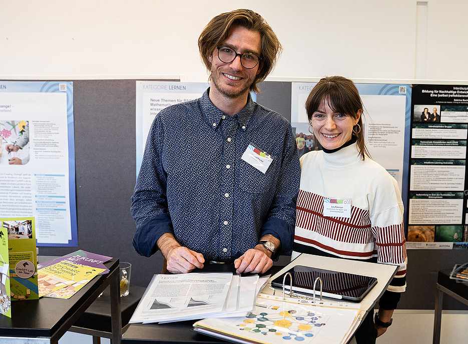 Michael Fischer and a colleague present materials from the project on a table ©Sacha Gillen/Forum Umweltbildung