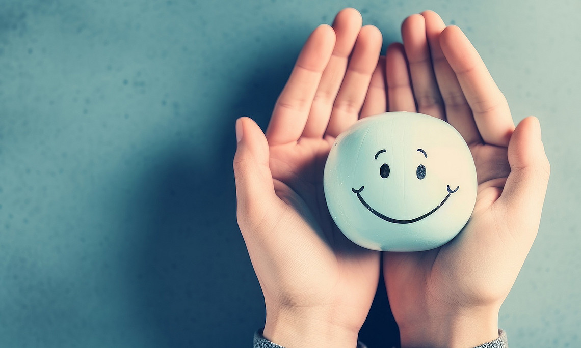 Holding a head with a happy smiling face in the hand
