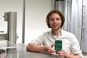 Johannes Bütow im Labor mit dem neuartigen Chip in der Hand