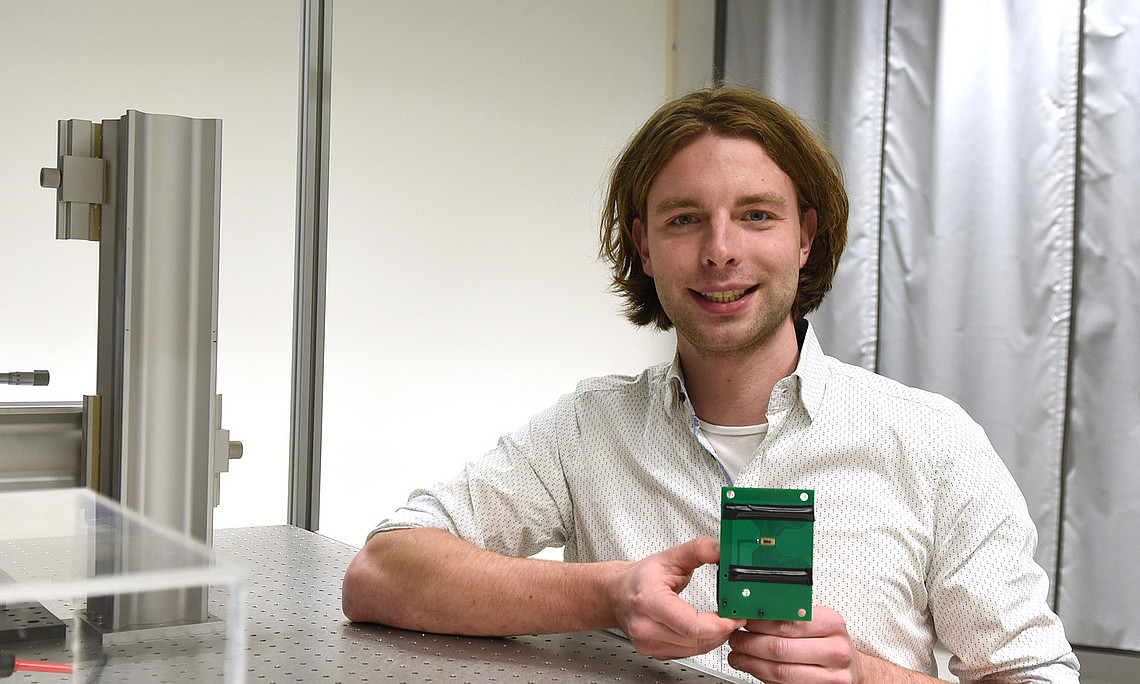 Johannes Bütow in the lab with the new chip in his hand
