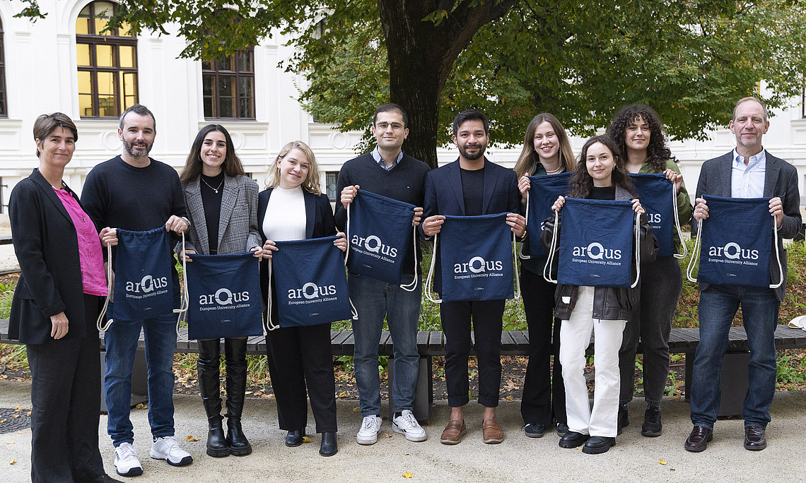 A group of people holding a bag with the inscription Arqus.