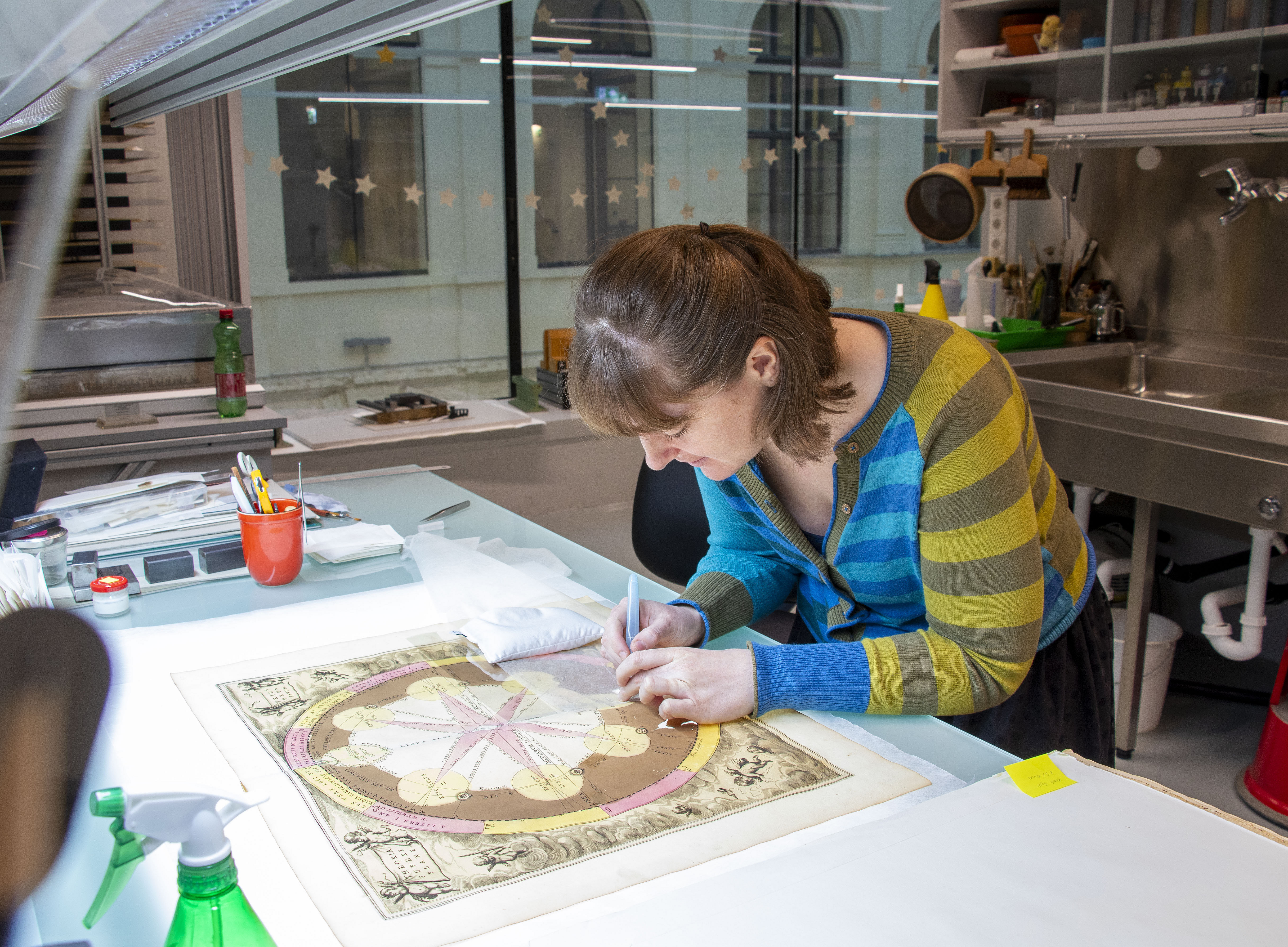 A woman is restoring a book. 