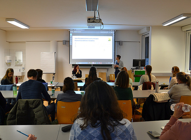 in einem Seminarraum sitzen zwei Frauen vor einer Leinwand und halten einen Vortrag; in den Tischreihen sitzen viele Menschen und hören zu ©Uni Graz/Braunegger