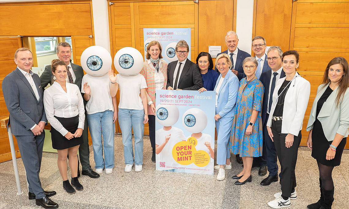 Gruppenfoto mit Vertreter:innen der Hochschulen, Industriellenvereinigung und Politik mit Maskottchen