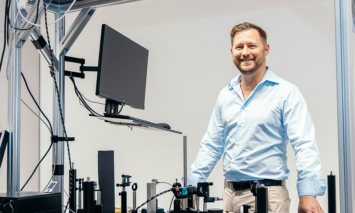 Jan Enenkel vor einer Versuchsanordnung in seinem Labor am Institut für Physik