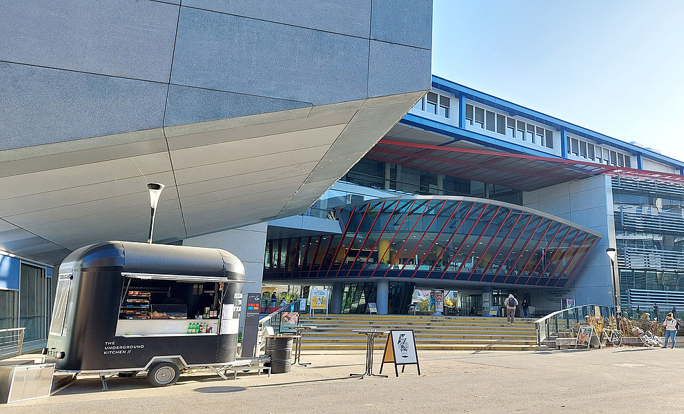 Blick aufs RESOWI, im Vordergrund der "Uni Bites"-Foodtruck