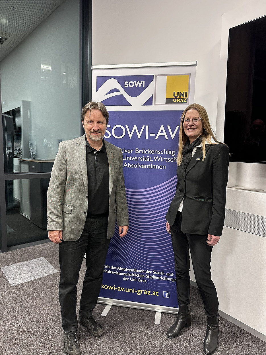 Mag. Dr. Ernst Sittinger und Mag. Sibylle Scaria stehen vor dem SOWI-AV Banner 