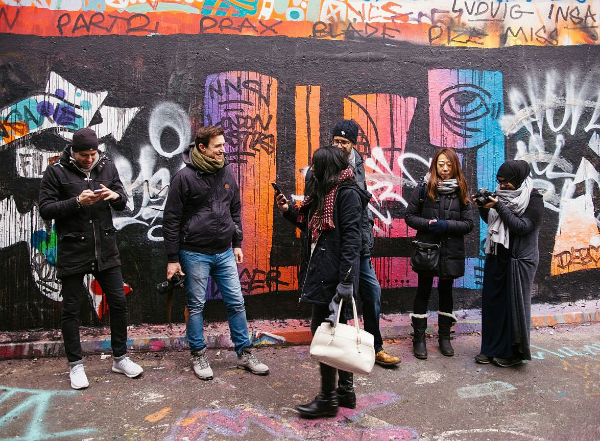 Gruppe junger Menschen vor Wand mit Graffitis ©clem onojeghuo by unsplash