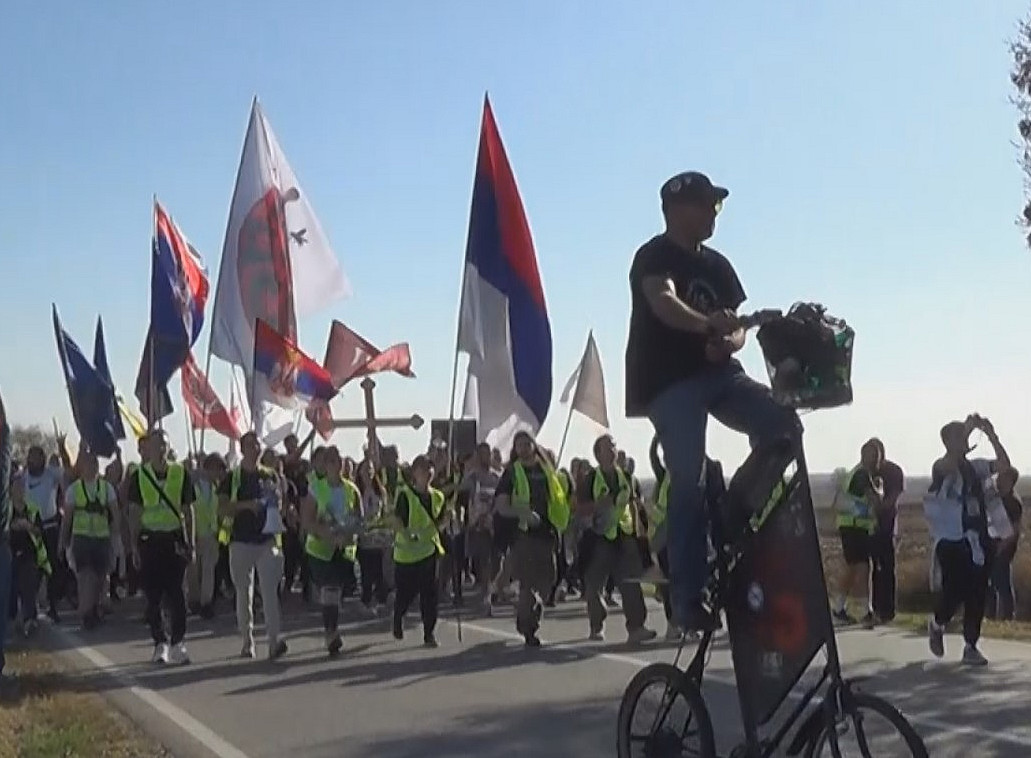ein Protestmarsch auf einer Landstraße, die Leute tragen serbische Flaggen ©Nikola Koruga and Bojana Milosavljević