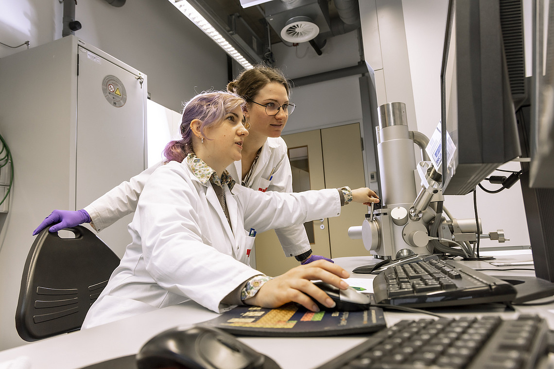 Zwei junge Frauen sitzen vor einem PC und symbolisieren die Studien der NAWI Graz
