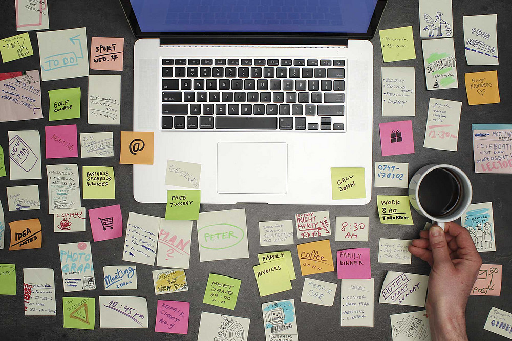 Laptop mit vielen Post-Its voller Notizen und einem Kaffee. ©kreus 