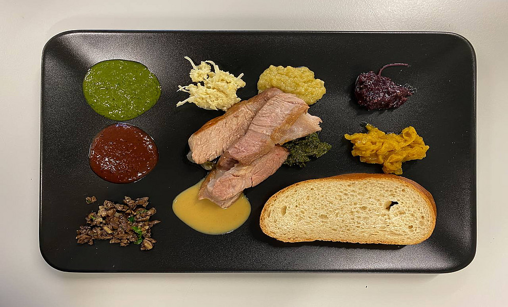 Ein Teller mit Fleisch und Soßen