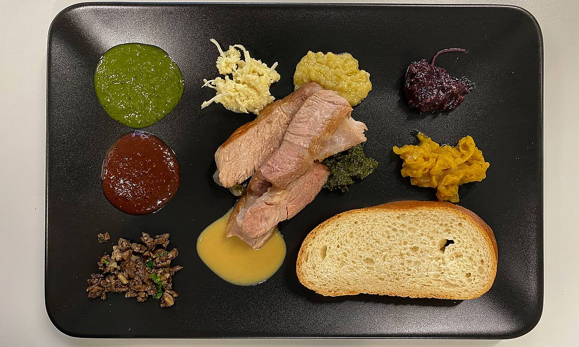 Ein fertig angerichteter Teller aus dem Grillkurs. Mit Fleisch und den verschiedensten Saucen.