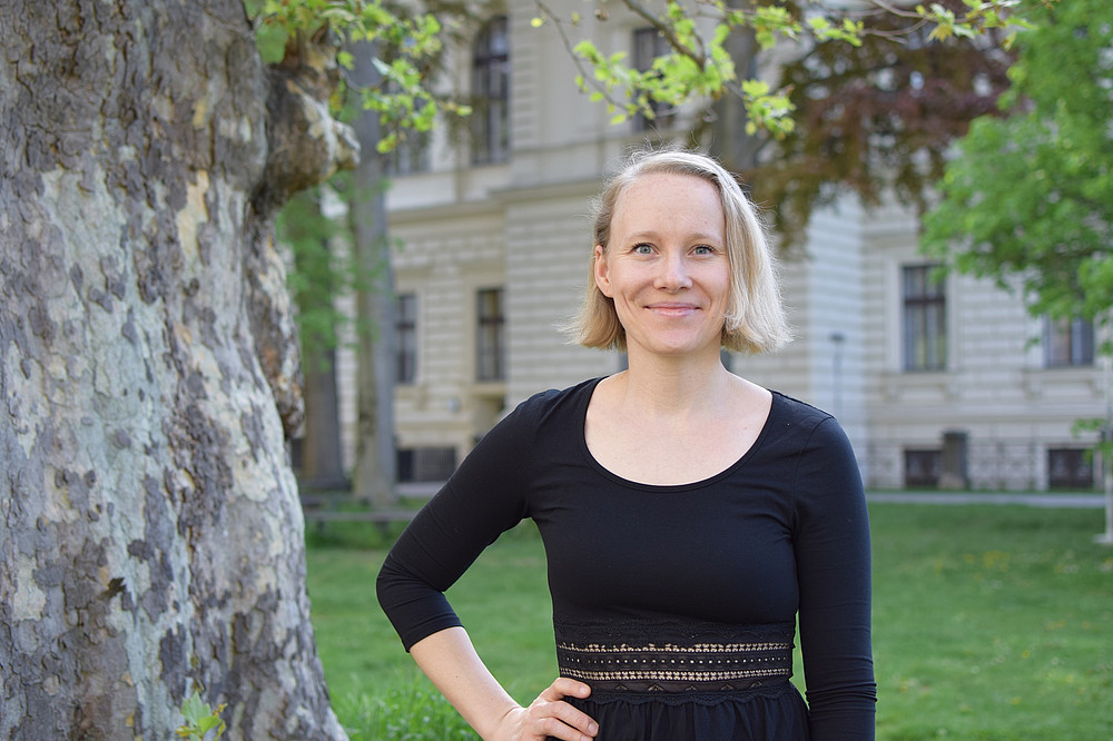 Portrait Sally Baumann next to tree on Uni Graz campus ©Ulrike Freitag/Uni Graz