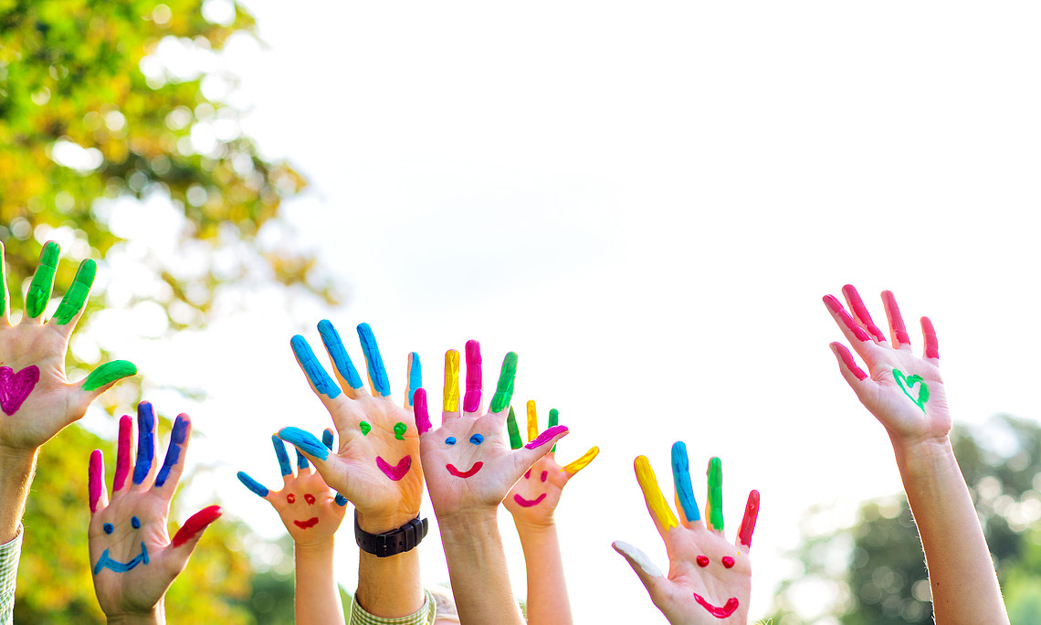 bunte Kinderhände werden hochgehalten