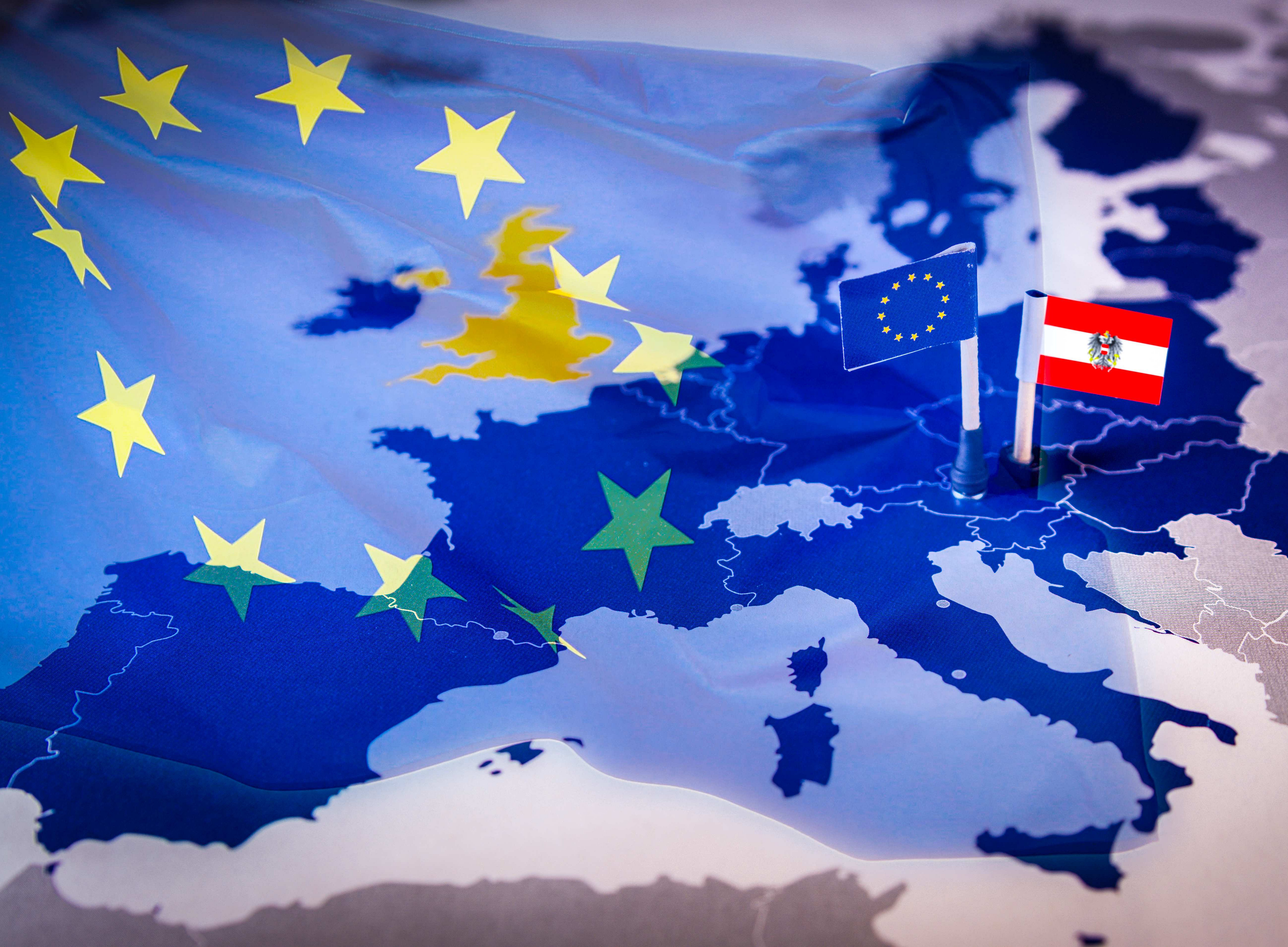 Europäische und Österreichische Flagge auf einer Europakarte 