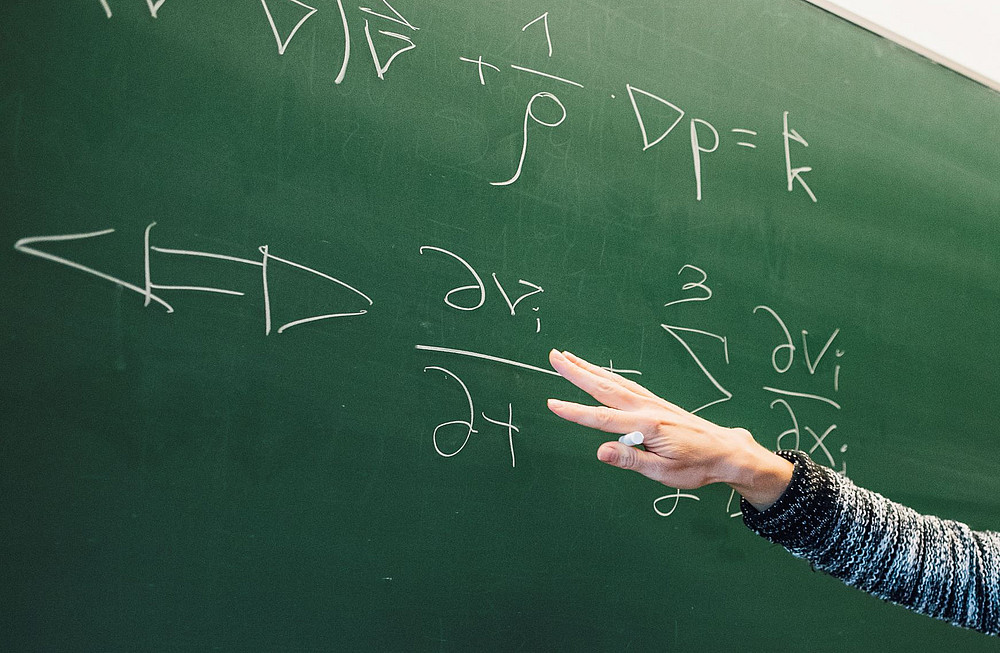 Blackboard with arm pointing to a formula ©Kanizaj/Universität Graz