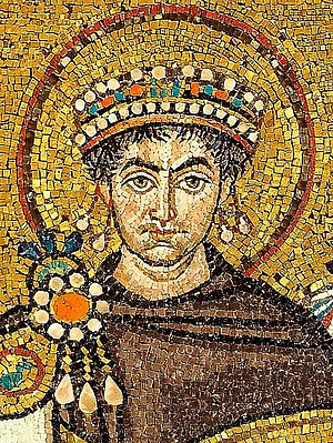 Ein Mosaikbild von Justinian in braunen Priestergewand mit einer mehrfarbigen Krone 