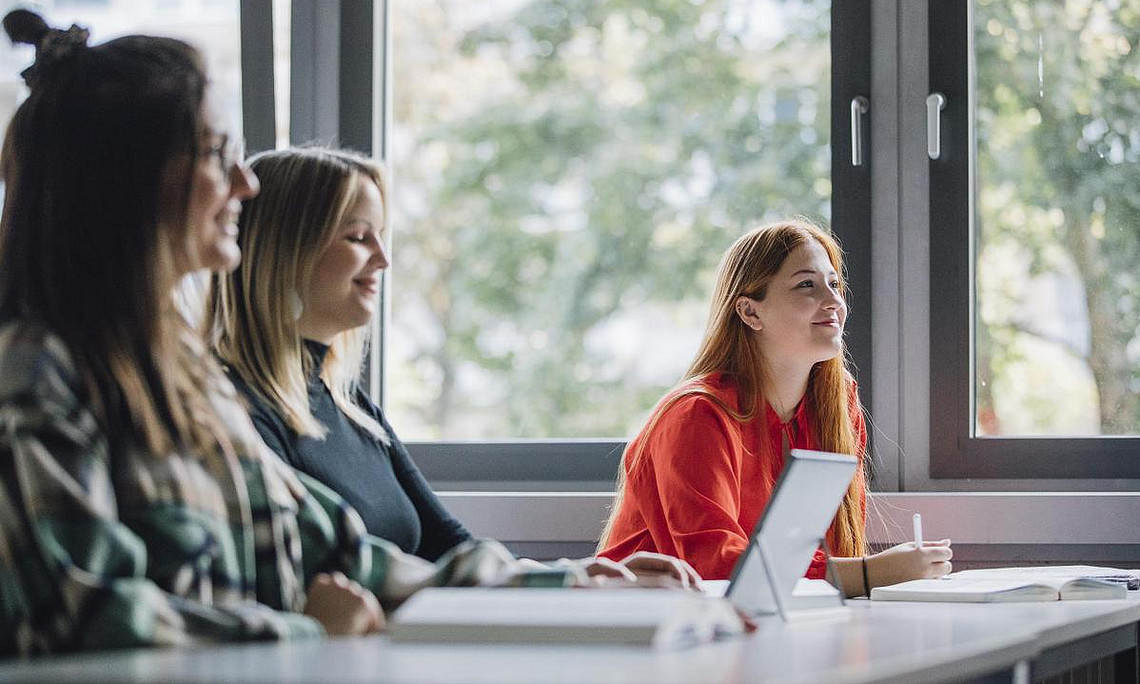 Studierende der Uni Graz, die an einem Tisch sitzen und aufmerksam zuhören, was in der Weiterbildungsveranstaltung gesporchen wird.