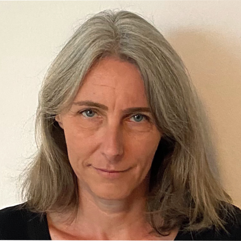 Portrait von einer Frau mit schulterlangen grauen Haaren und blauen Augen