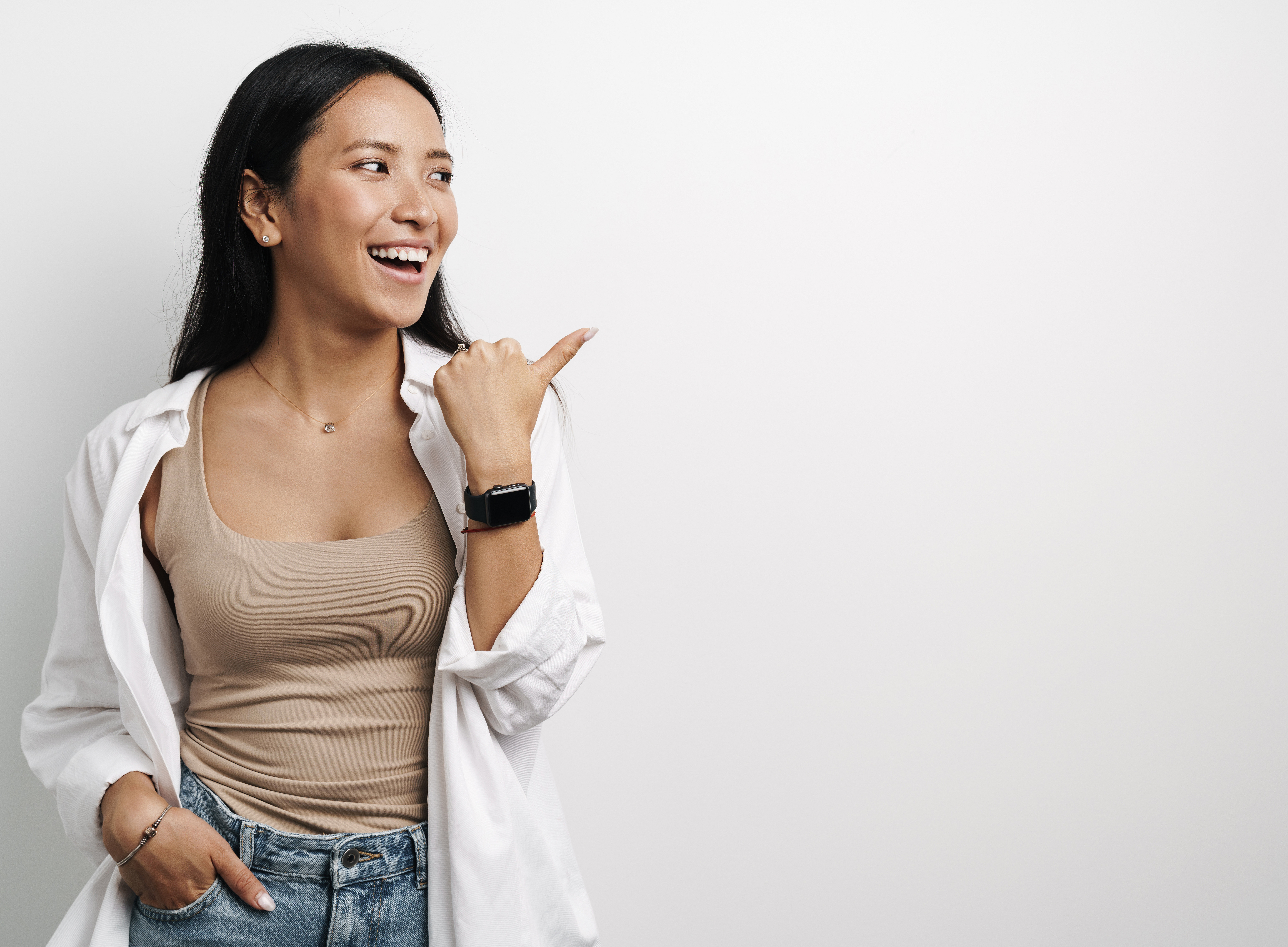 Beautiful Happy Asian Woman Laughing and Pointing Finger Aside ©Adobe Stock