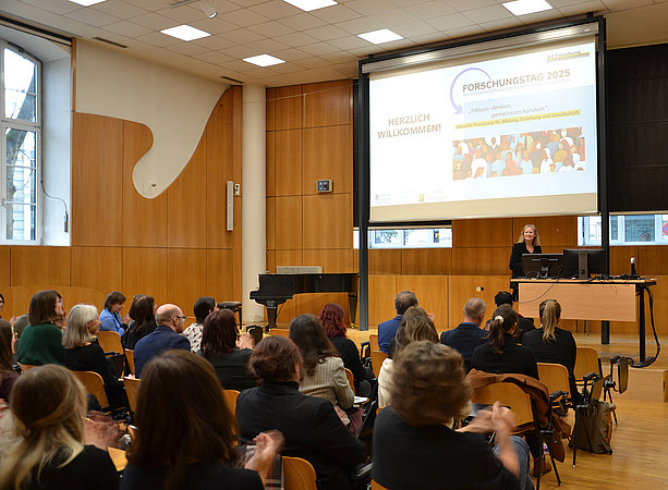 eine Frau steht in einem Hörsaal auf einem Podium und spricht, im Publikum sitzen viele Menschen und hören zu ©Uni Graz/Braunegger